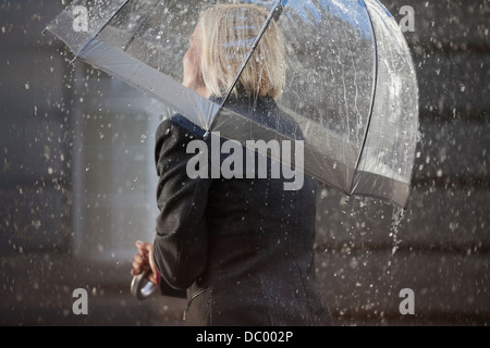 Businesswoman under umbrella in rain Banque D'Images