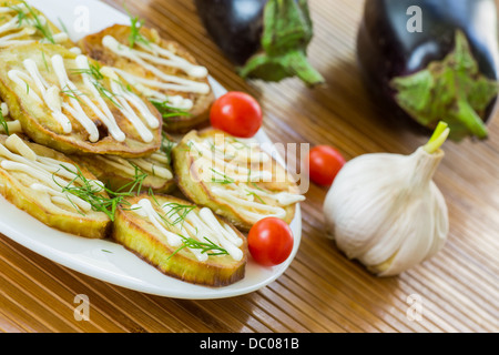 Aubergines frites avec de la mayonnaise et l'ail sur une plaque Banque D'Images