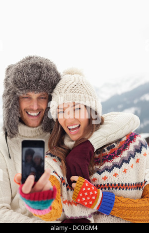 Couple enthousiaste taking self-portrait with camera phone Banque D'Images