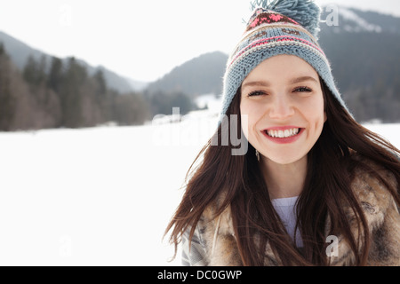 Close up portrait of happy woman wearing Knit hat in snowy field Banque D'Images