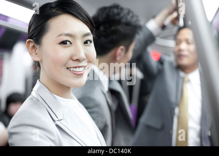 Cheerful businesswoman avec ses partenaires de Subway train Banque D'Images