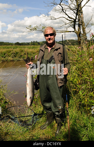 Un pêcheur pêcheur tenant un saumon capturé dans la rivière Towy Tywi Carmarthenshire Wales Cymru UK GO Banque D'Images