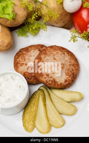 Petites escalopes de viande avec la sauce et garnir on white plate Banque D'Images