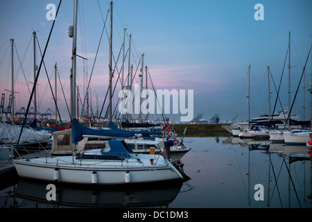Yachts amarrés dans Shotley Marina, Suffolk Felixstowe port à conteneurs, avec en arrière-plan. Banque D'Images
