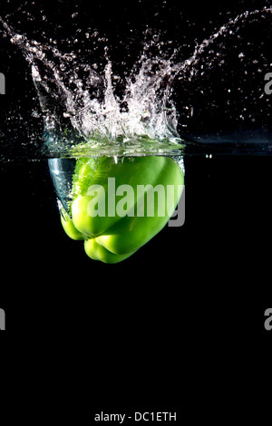 Paprika vert frais splash dans l'eau sur fond noir Banque D'Images