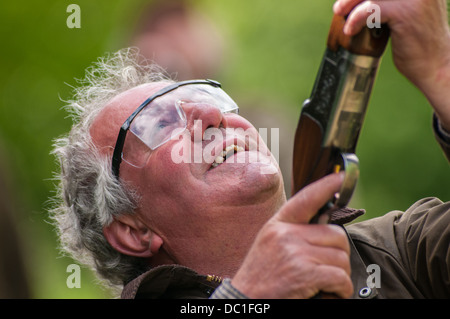 Portrait d'un homme tirant sur une simulation de tir jeu shoot argile porter des lunettes de protection Banque D'Images