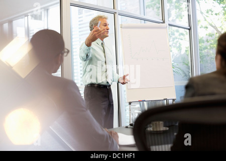 Businessman gesturing at flipchart en réunion Banque D'Images