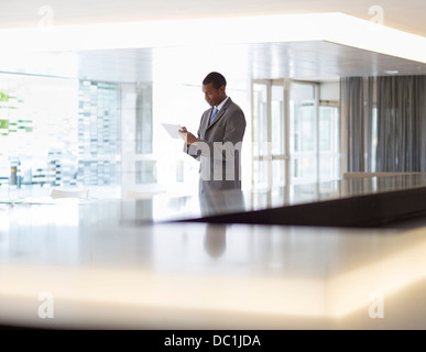 Businessman using digital tablet in lobby Banque D'Images