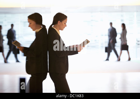 Businesswoman using digital tablet in lobby Banque D'Images