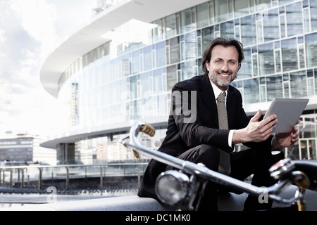 Mid adult businessman using digital tablet in city, portrait