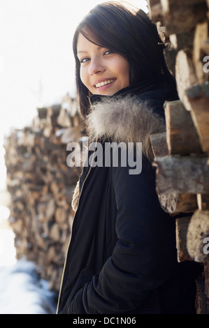 Portrait de jeune femme en face de pile de journaux Banque D'Images