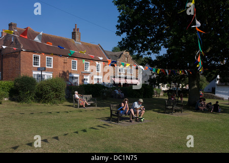 Pennents et banderoles sur la place du village à Horning, un village touristique sur les Norfolk Broads. Les habitants et les touristes, vous pourrez vous détendre dans l'après-midi, soleil d'été que l'azuré s'agite au-dessus de têtes. Horning est un ancien village et de la paroisse dans le comté anglais de Norfolk. Horning désigne le 'folk qui vivent sur les hauteurs entre les rivières'. Son histoire remonte à 1020 quand le manoir a été donné par le roi Canut à l'abbaye de St Benet à Hulme. Horning est pittoresque, et décrit comme le plus joli village sur les broads. Banque D'Images