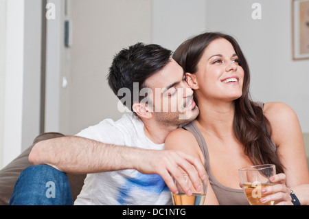 Young couple sitting on sofa partager verre de vin Banque D'Images