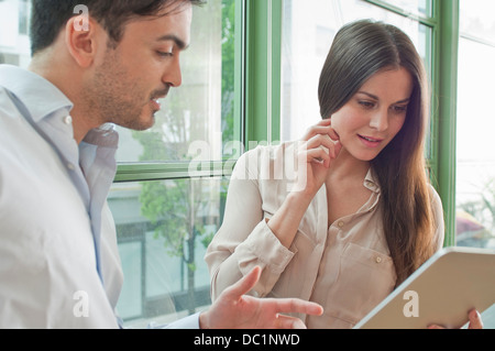 Les jeunes travailleurs de bureau looking at digital tablet Banque D'Images