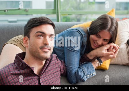 Jeune couple flânant sur canapé Banque D'Images