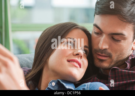 Jeune couple romantique flânant sur canapé Banque D'Images