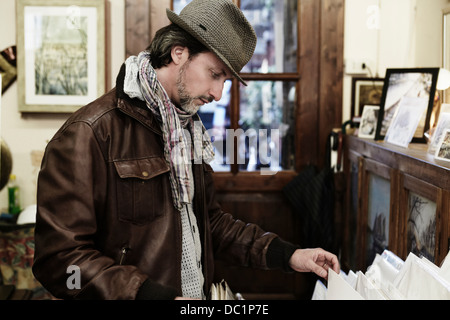 Mid adult man browsing in antique shop Banque D'Images