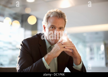 Portrait of smiling businessman with hands clasped Banque D'Images