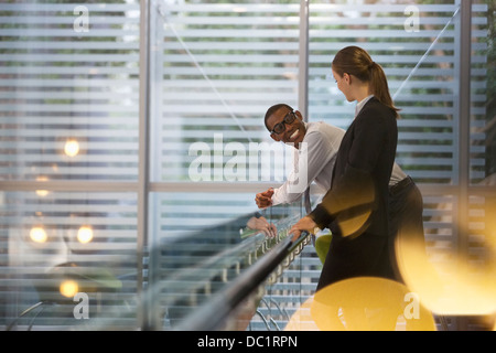 Smiling businessman and businesswoman talking in office Banque D'Images