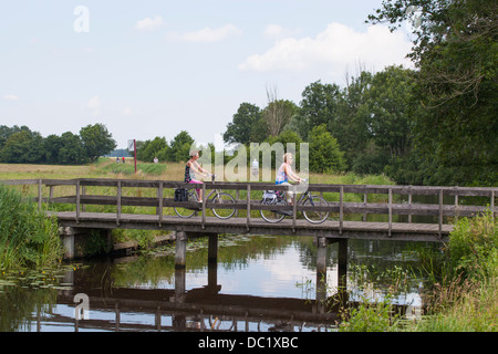 Les cyclistes passant un pont sur un canal à la province de Groningue, dans le nord des Pays-Bas Banque D'Images