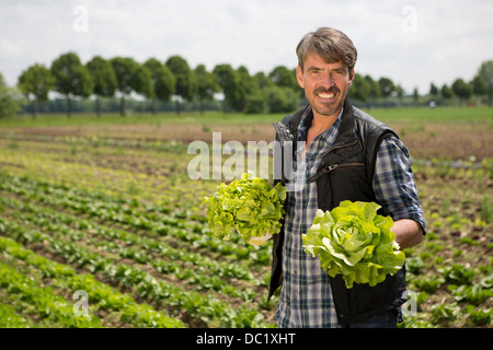 Portrait of organic farmer holding lettuce Banque D'Images