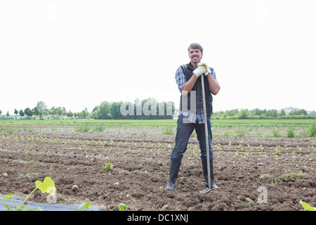 Portrait de l'agriculteur biologique avec rake Banque D'Images