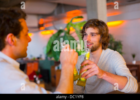 Deux hommes avec des bouteilles de bière Banque D'Images