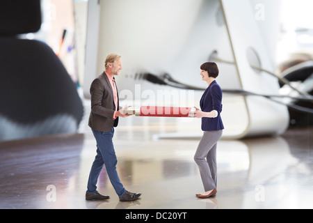 Collègues de bureau transportant un grand stick USB sur un immense bureau Banque D'Images