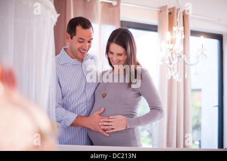 Expectant couple touching baby bump Banque D'Images