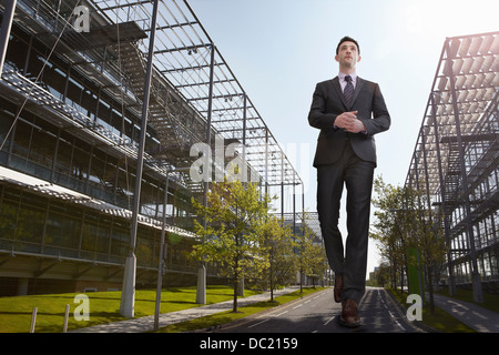 De grands businessman walking on road, low angle view Banque D'Images