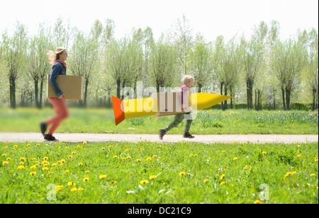 Mid adult woman running avec fils en fusée en carton Banque D'Images