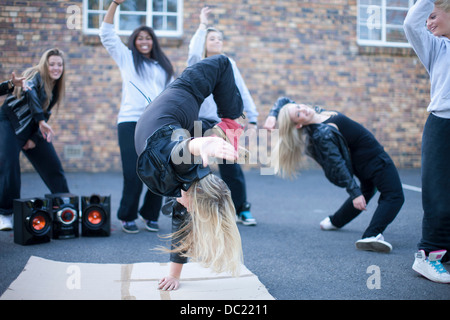 Fille blonde breakdancing in playground Banque D'Images