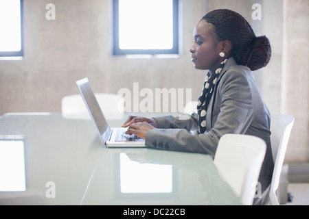 Young woman using laptop in boardroom Banque D'Images