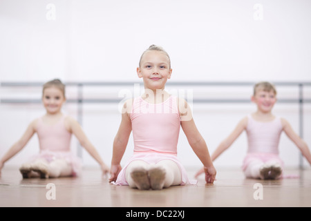 Les jeunes ballerines en posent assis sur le plancher Banque D'Images