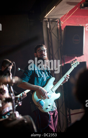 Les hommes jouant guitares sur scène en club Banque D'Images