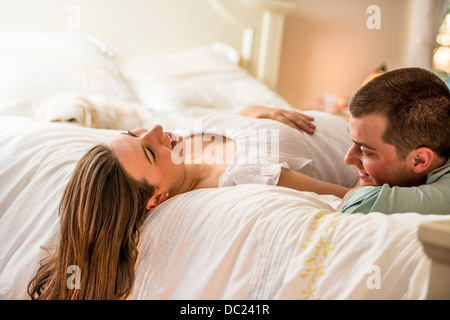 Pregnant couple lying on bed Banque D'Images