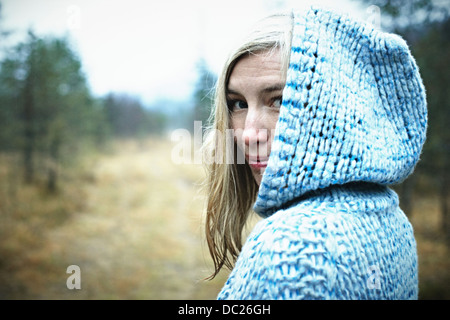 Woman wearing hooded top in forest Banque D'Images