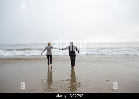 Young couple holding hands on beach Banque D'Images