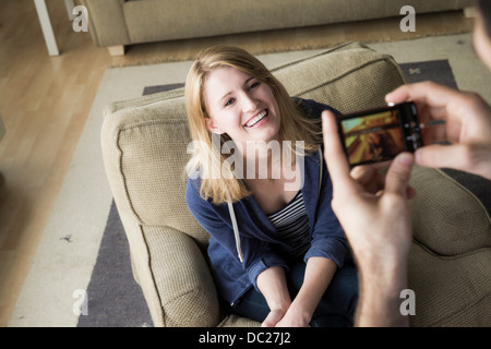 Man photographing young woman on cell phone Banque D'Images