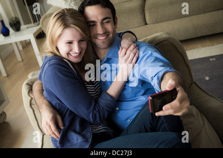 Jeune couple photographing themselves on cell phone Banque D'Images