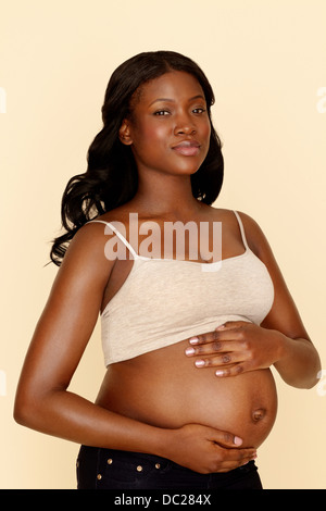 Jeune femme enceinte touching stomach Banque D'Images