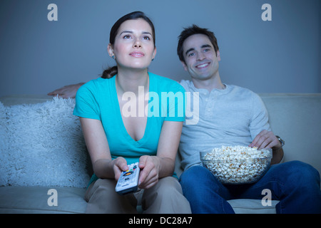 Couple watching television with popcorn Banque D'Images