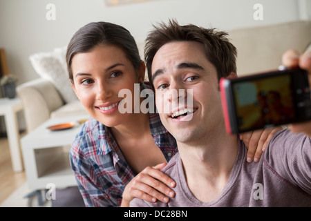 Couple photographing themselves with camera phone Banque D'Images