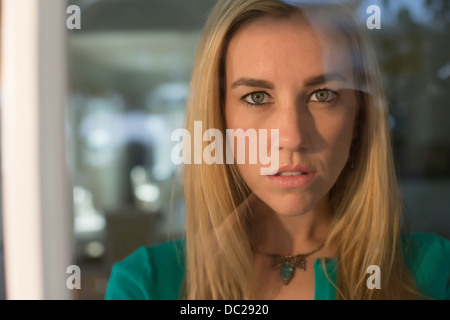 Portrait de jeune femme regardant par la fenêtre Banque D'Images