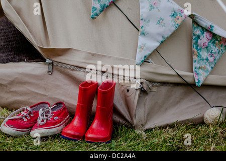 Espadrilles rouge et rouge à l'extérieur de welliingtons tente avec bunting Banque D'Images