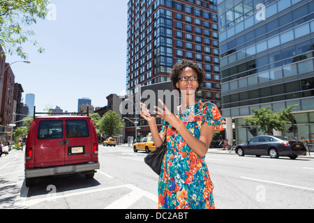 Femme dans la rue Bay holding digital tablet Banque D'Images