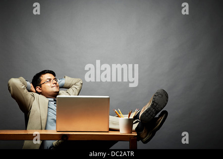 Man relaxing with feet up on table Banque D'Images