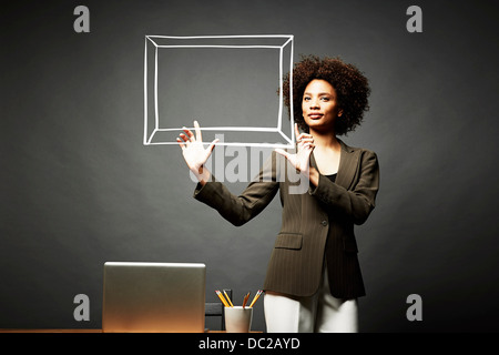 Woman holding up un cadre photo Banque D'Images