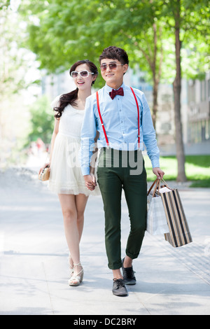 Jeune couple élégant walking with shopping bags in hand Banque D'Images