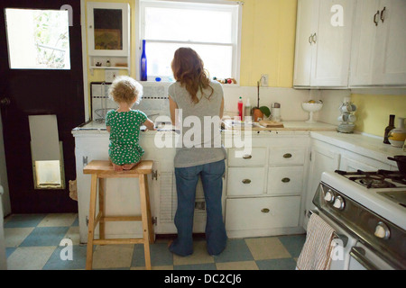 La mère et l'enfant à l'évier de cuisine Banque D'Images